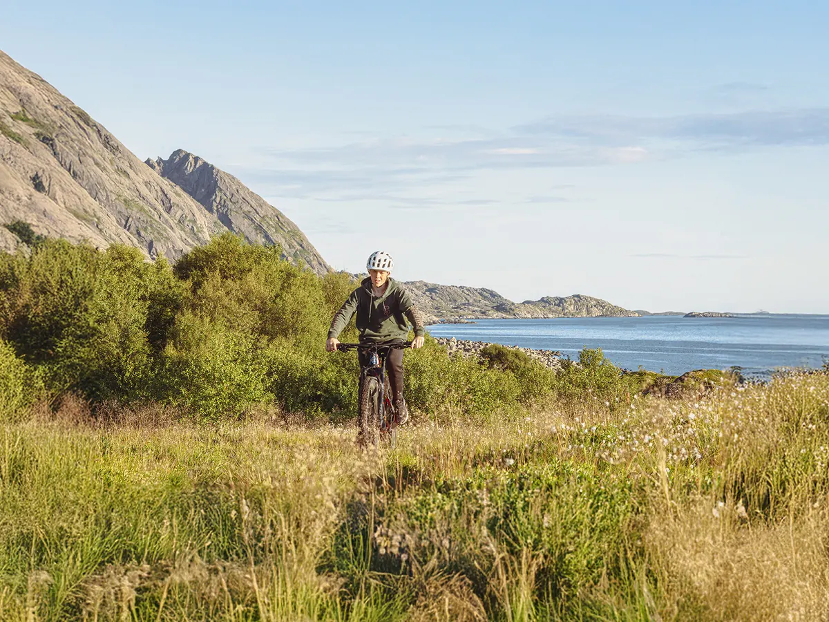 Syklist på sti i lyngen ved sjøen